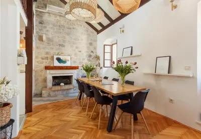a dining room with a table and chairs and a fireplace at Old Town St Tryphon Apartment in Kotor