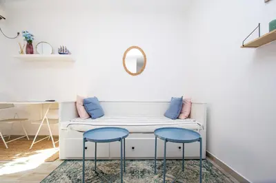 a living room with a white couch and two blue stools at Budva Apartment Nadja in Budva