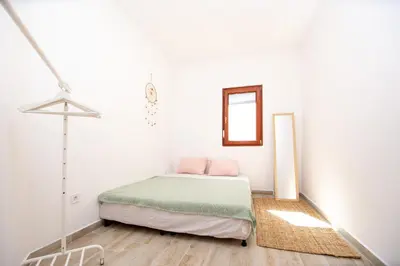 a white bedroom with a bed and a mirror at Budva Apartment Nadja in Budva