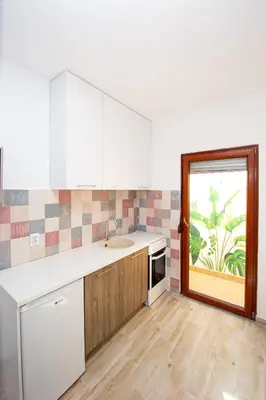 a kitchen with white cabinets and a sink and a window at Budva Apartment Nadja in Budva