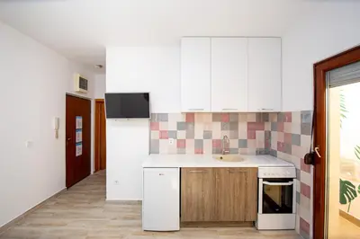 a kitchen with white cabinets and a sink at Budva Apartment Nadja in Budva