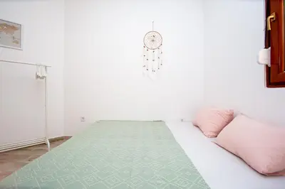 a bedroom with a bed with pink pillows and a clock at Budva Apartment Nadja in Budva