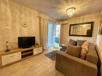 a living room with a couch and a television at Apartman M&U in Petrovac na Moru
