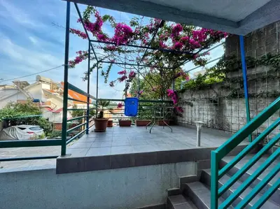 a balcony with pink flowers on a building at Apartman M&U in Petrovac na Moru