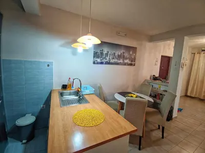 a kitchen with a sink and a table with chairs at Apartman M&U in Petrovac na Moru