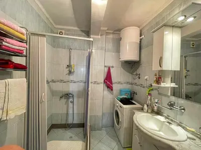 a bathroom with a shower and a sink and a washing machine at Apartman M&U in Petrovac na Moru
