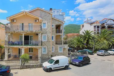 a white car parked in front of a building at Apartman AS in Budva