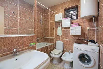 a bathroom with a washing machine and a toilet at Apartman AS in Budva
