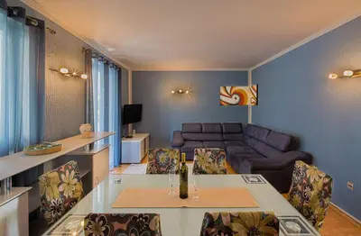 a living room with a couch and a table and chairs at Apartman AS in Budva