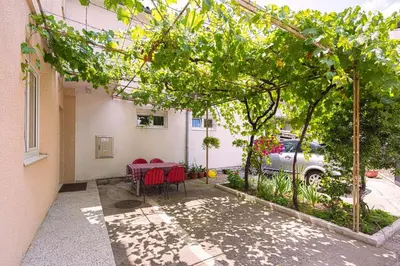 a patio with a table and chairs under a pergola at Apartman AS in Budva