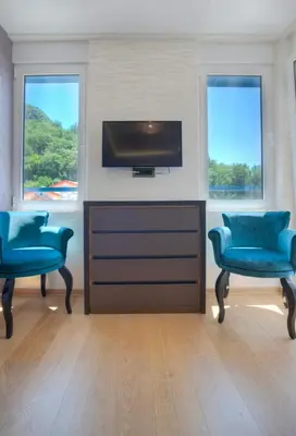 a living room with two blue chairs and a flat screen tv at Villa Katarina in Budva