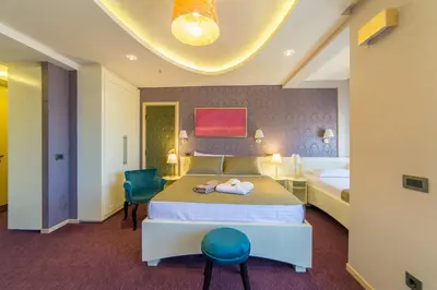 a hotel room with a bed and a chair at Villa Katarina in Budva