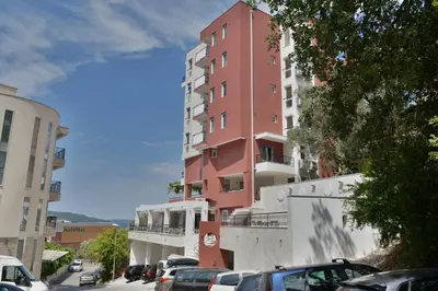 a tall red building on the side of a street at Villa Katarina in Budva