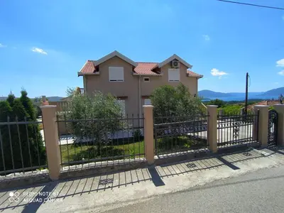 a fence in front of a house at Apartman Andjela in Kavač