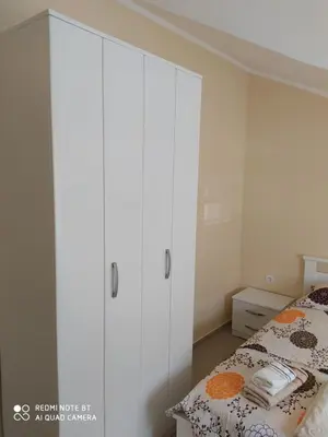 a bedroom with a bed and a white cabinet at Apartman Andjela in Kavač