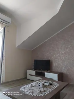 a living room with a tv and a table at Apartman Andjela in Kavač