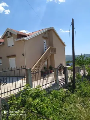 a house with a fence in front of it at Apartman Andjela in Kavač