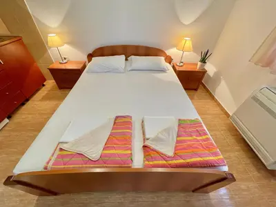 a bedroom with a large white bed with two pillows at Apartments Boreta Becici in Budva