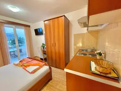 a small kitchen with a bed and a sink at Apartments Boreta Becici in Budva
