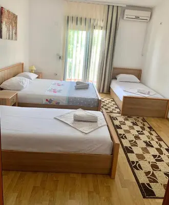 a bedroom with two beds and a window at Beqa Apartments in Ulcinj