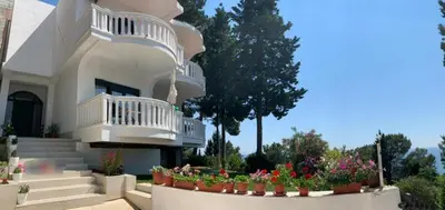 a large white house with flowers in pots at Beqa Apartments in Ulcinj
