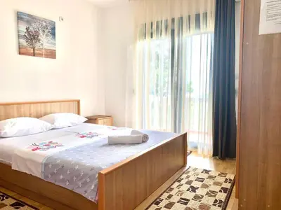 a bedroom with a bed and a large window at Beqa Apartments in Ulcinj