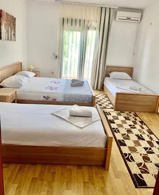 a bedroom with two beds and a window at Beqa Apartments in Ulcinj