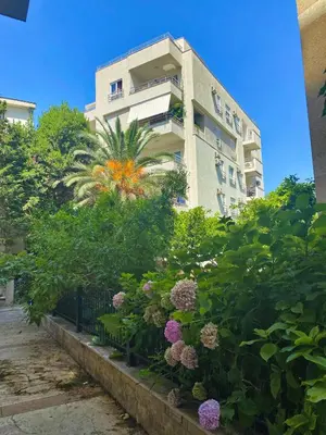 a building with a bunch of flowers in front of it at Modern Studio 200m from the Beach in Budva