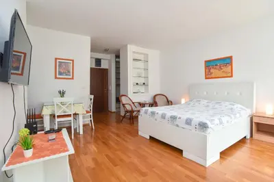 a bedroom with a bed and a living room at Modern Studio 200m from the Beach in Budva
