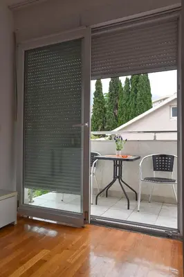 a sliding glass door with blinds on a patio at Modern Studio 200m from the Beach in Budva