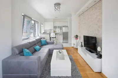 a living room with a couch and a tv at City center lux apartment in Budva