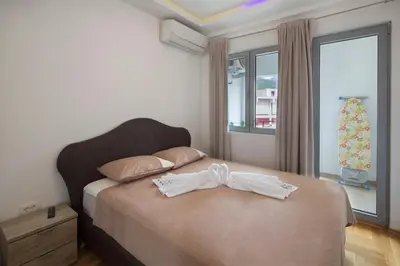 a bedroom with a bed with a bow tie on it at City center lux apartment in Budva