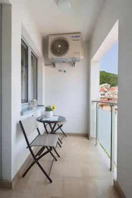a balcony with a table and chairs and a fan at City center lux apartment in Budva