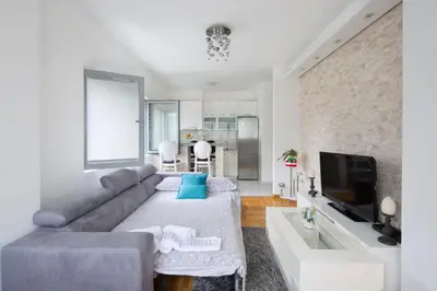 a living room with a couch and a tv at City center lux apartment in Budva