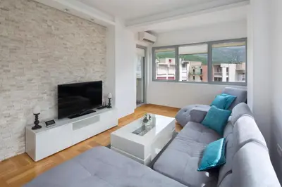 a living room with a couch and a tv at City center lux apartment in Budva