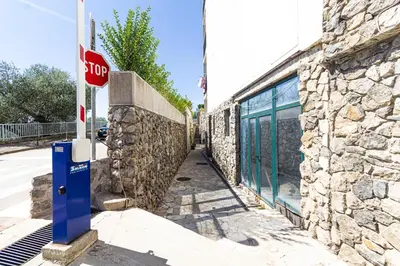 a stop sign in front of a stone building at Miramare Apartments Pržno in Pržno