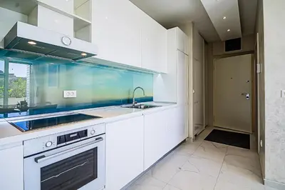 a white kitchen with a sink and a stove at Miramare Apartments Pržno in Pržno