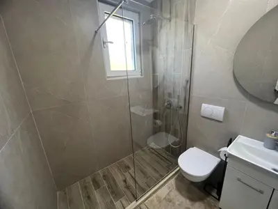 a bathroom with a shower and a toilet and a sink at Apartments San with Sea View in Dobra Voda