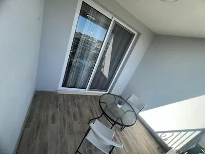a room with a glass table and two windows at Apartments San with Sea View in Dobra Voda