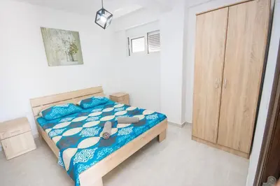 a bedroom with a bed with a teddy bear on it at Apartments San with Sea View in Dobra Voda