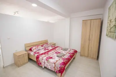 a bedroom with a bed and a wooden cabinet at Apartments San with Sea View in Dobra Voda