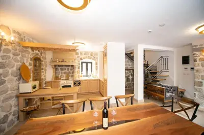 a kitchen with a wooden table and chairs in a room at SEASIDE HOUSE KOTOR in Kotor