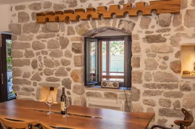 a stone wall with a table and a window at SEASIDE HOUSE KOTOR in Kotor