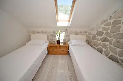 two twin beds in a room with a window at SEASIDE HOUSE KOTOR in Kotor