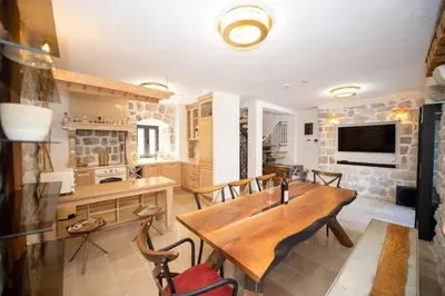 a kitchen and dining room with a wooden table and chairs at SEASIDE HOUSE KOTOR in Kotor