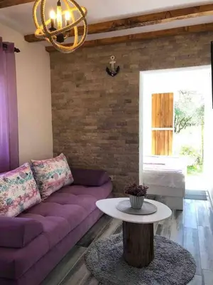 a living room with a purple couch and a table at Rajana Bungalow 2olive House in Ulcinj