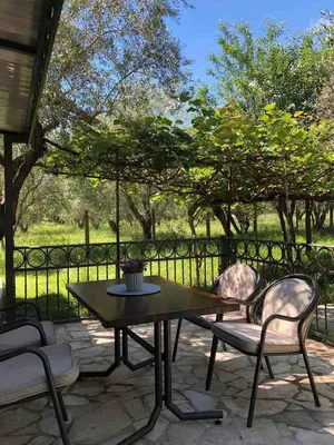 a patio with a table and chairs and a fence at Rajana Bungalow 2olive House in Ulcinj
