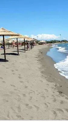 a beach with umbrellas and people on the sand at Rajana Bungalow 2olive House in Ulcinj