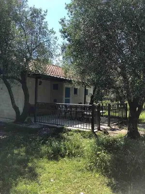 a house with a wooden fence and trees at Rajana Bungalow 2olive House in Ulcinj