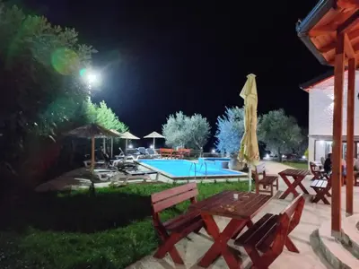 a swimming pool in a yard at night at Rustic Villas Barlovic in Ulcinj
